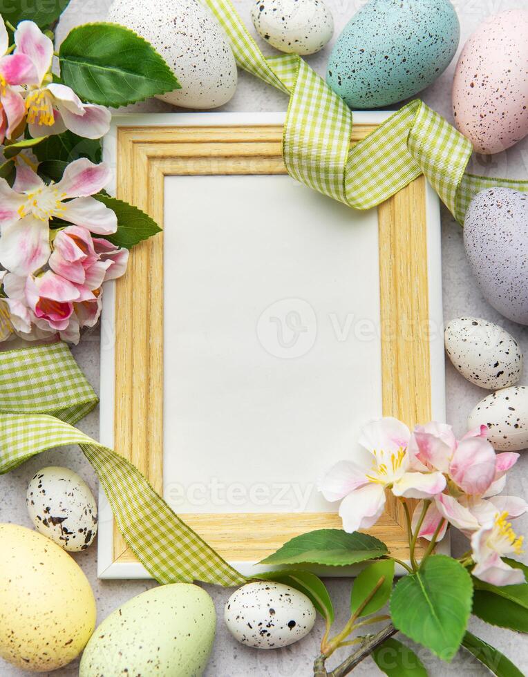 Easter eggs and spring flowers framing empty frame photo