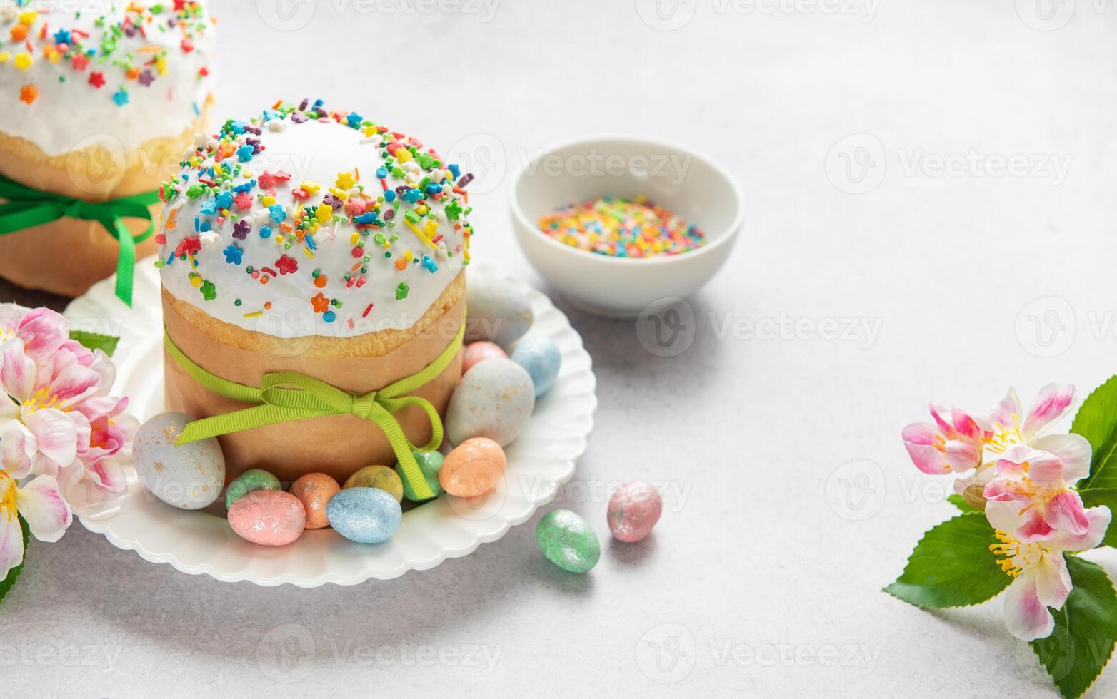Easter cakes decorated with colorful sprinkles and chocolate eggs on festive table photo