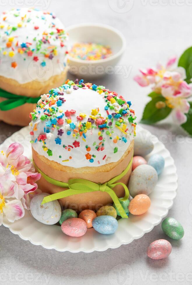 Easter cakes decorated with colorful sprinkles and chocolate eggs on the table photo