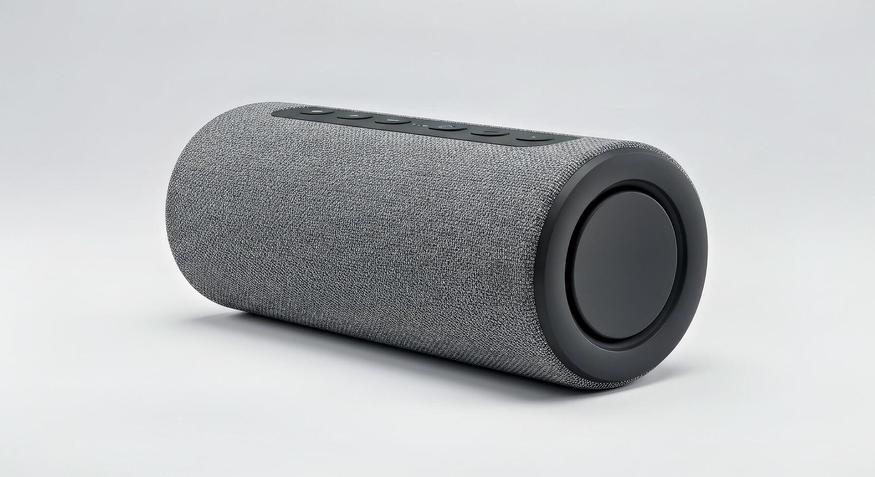 A gray speaker with a black cover on a white surface photo
