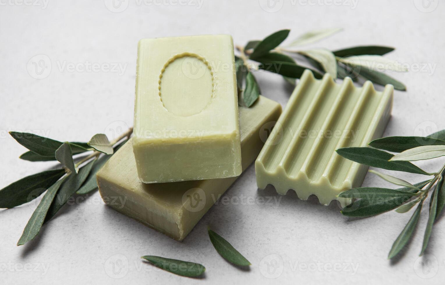 Olive soap bars resting on marble surface with olive branches photo