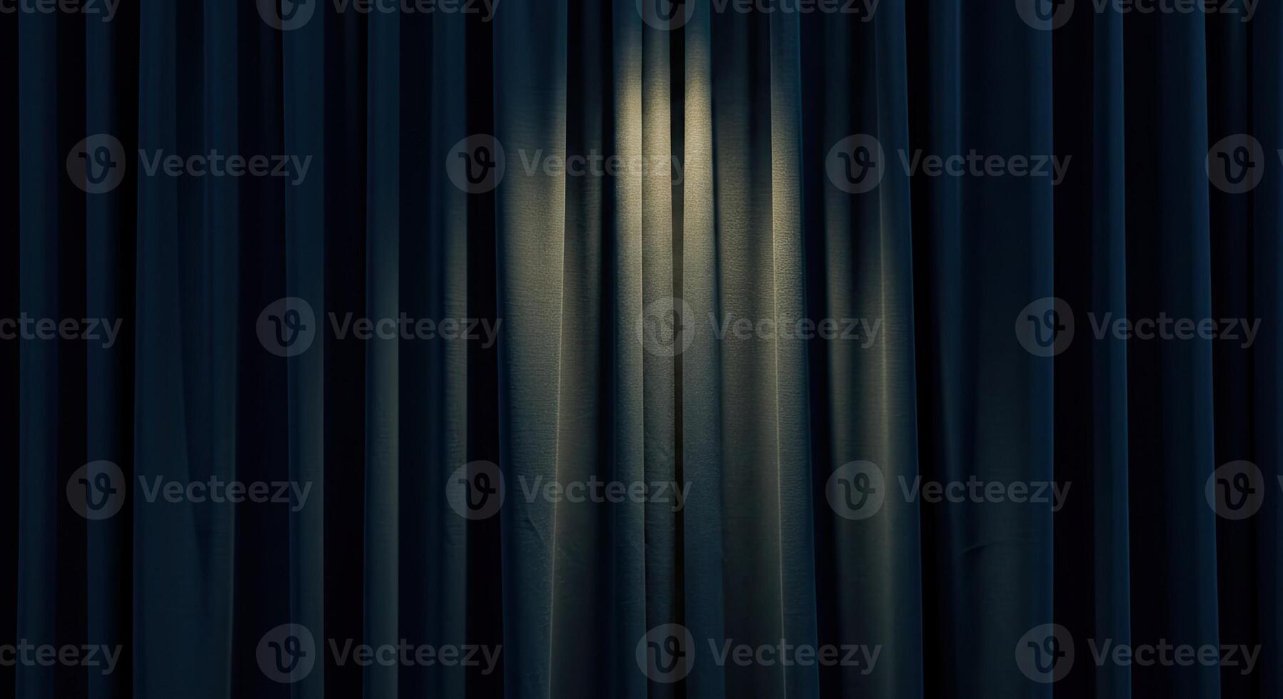 A dark curtain with a light shining through it photo