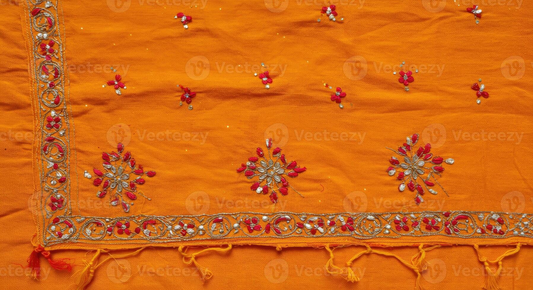 An orange colored sari with red and white embroidery photo