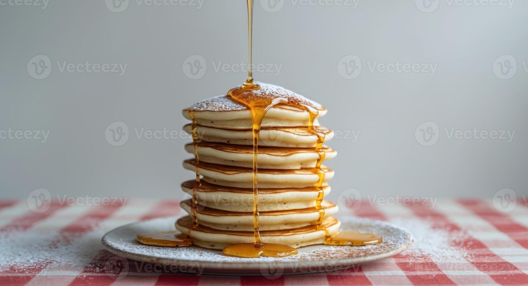 A stack of pancakes with syrup being poured over them photo