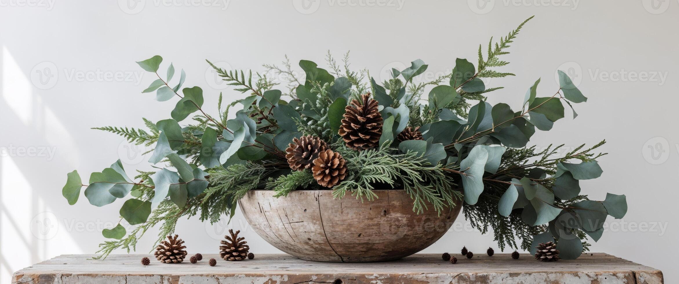 Cozy Holiday Decor Featuring Fresh Greenery and Pine Cone in a Natural Wooden Bowl on Rustic Table photo