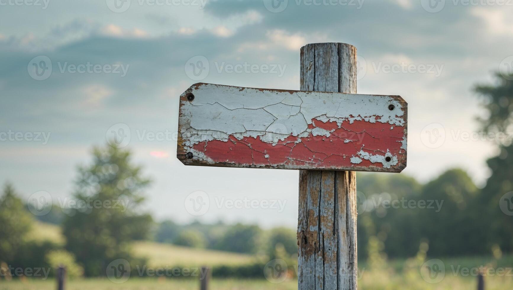 A red and white sign on a wooden post photo