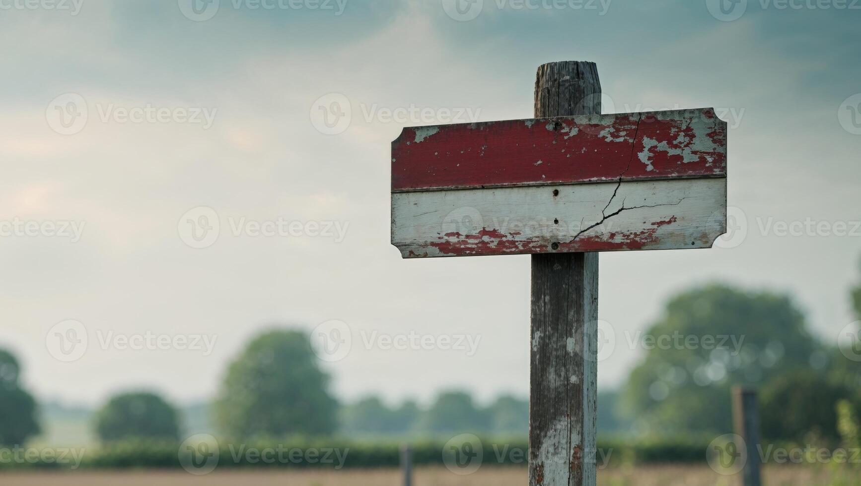 A red and white sign on a wooden post photo