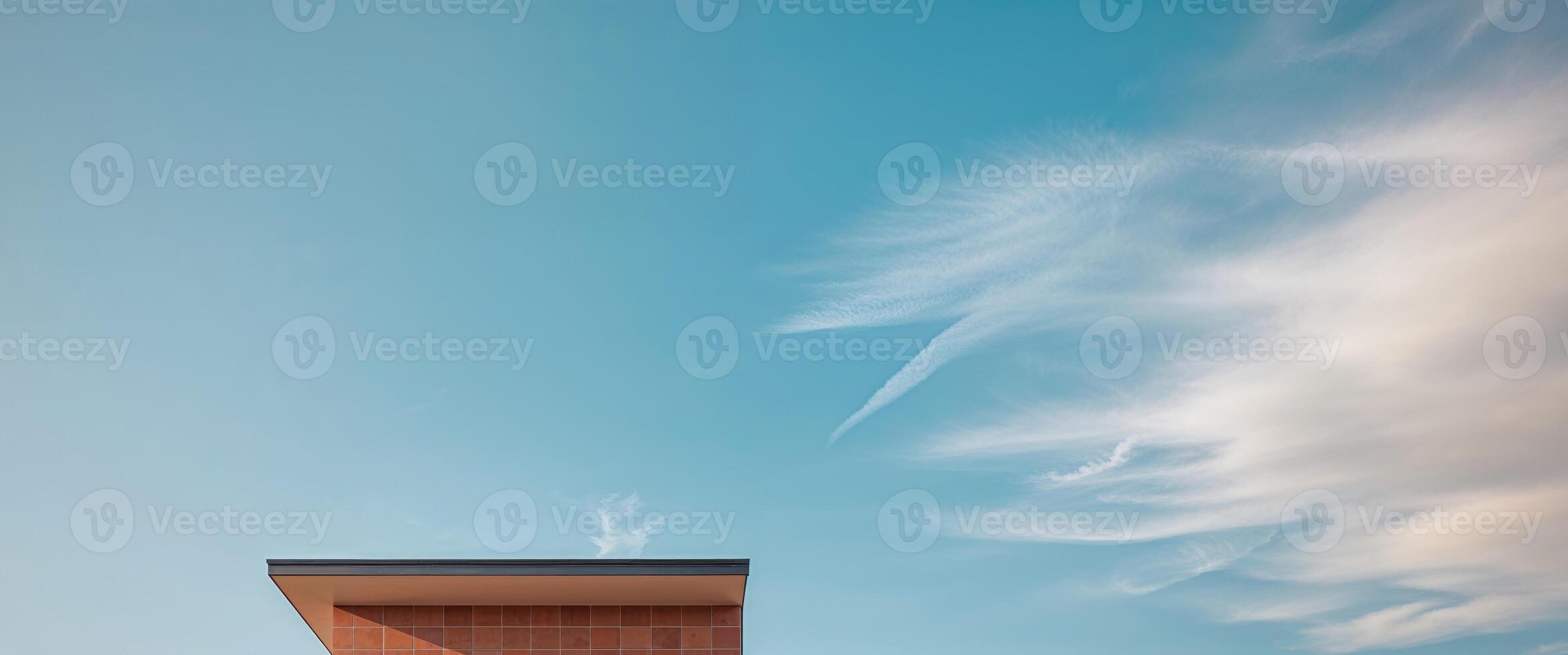 A brick building with a chimney and a cloud in the sky photo
