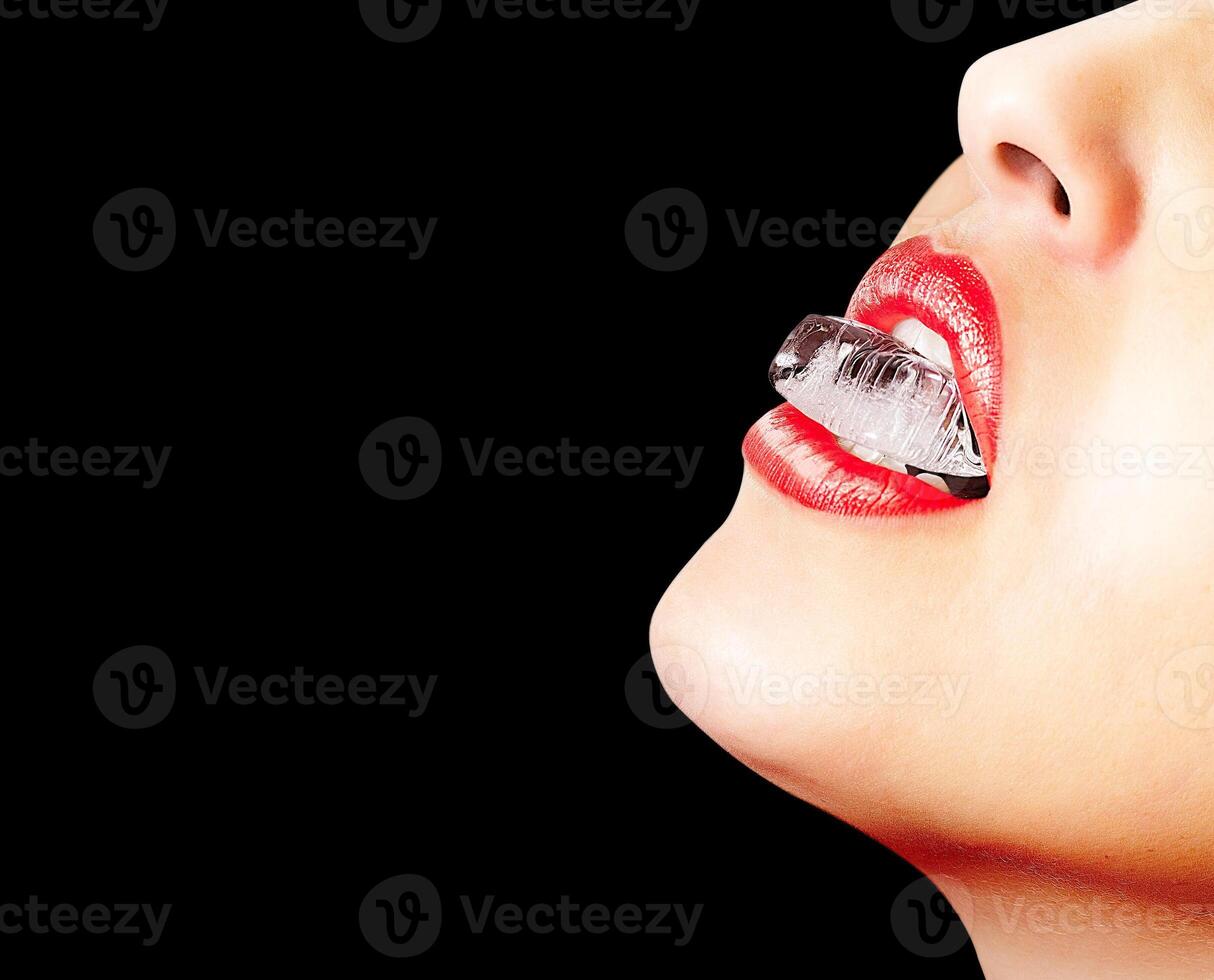 Closeup of red lips whit an ice cube photo