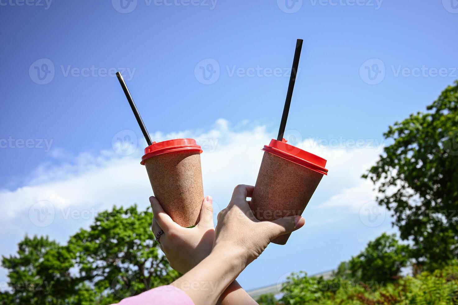 Two cups of paper coffee, relaxing in a sunny spring green urban park in nature. The concept of urban leisure. photo