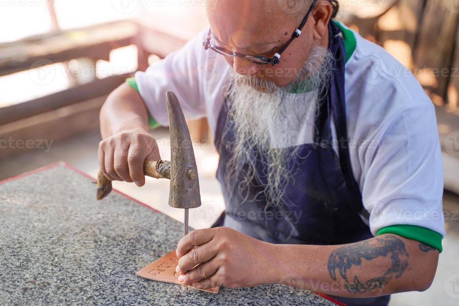 Closeup leather craftsman is carefully to make a leather product for a customer. photo