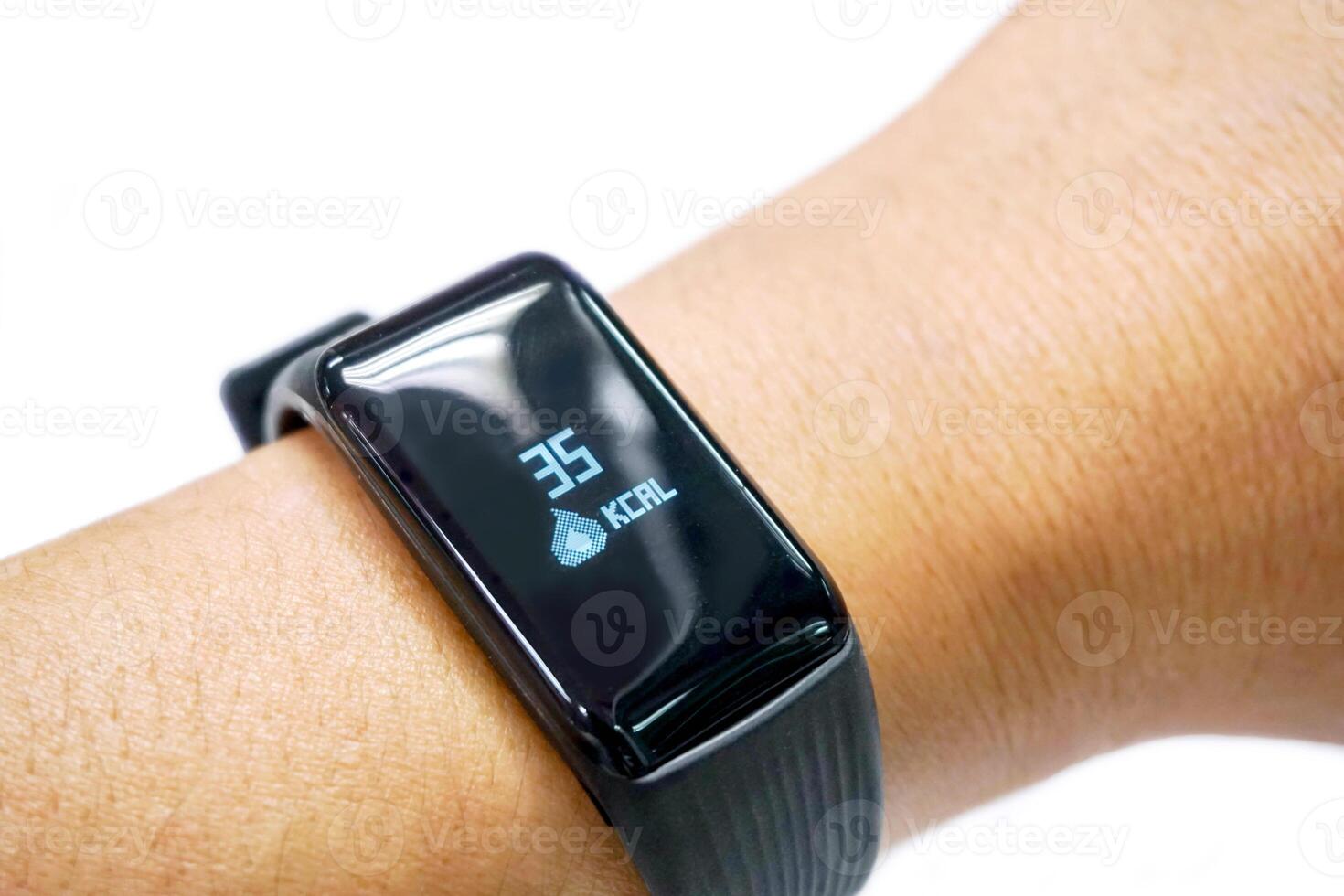 Closeup human's hand wear black healthy smart band with numbers and icon of calories burned display on screen isolate on white background. photo