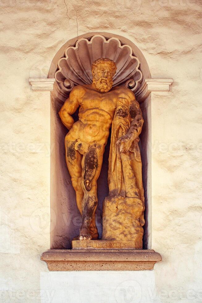 Statue of Hercules - mythological strongman, mythical male figure, in a niche, wall around photo