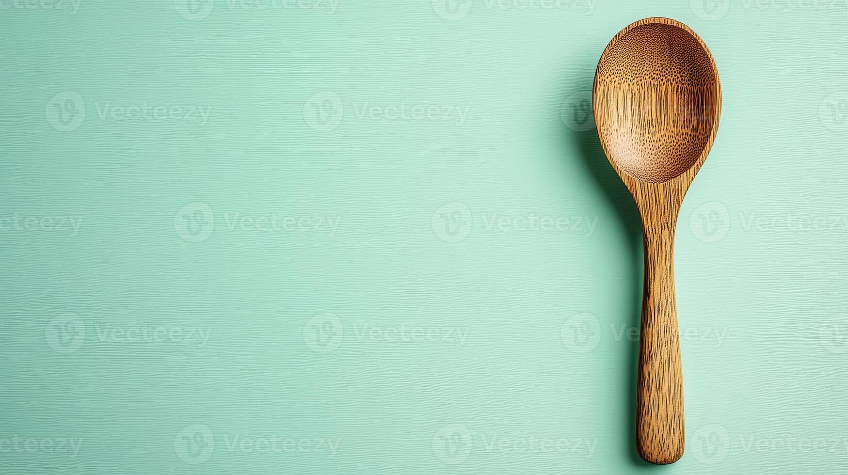 Minimalist Wooden Spoon on a Soft Mint Background for Kitchen Decor and Cooking Enhancement photo