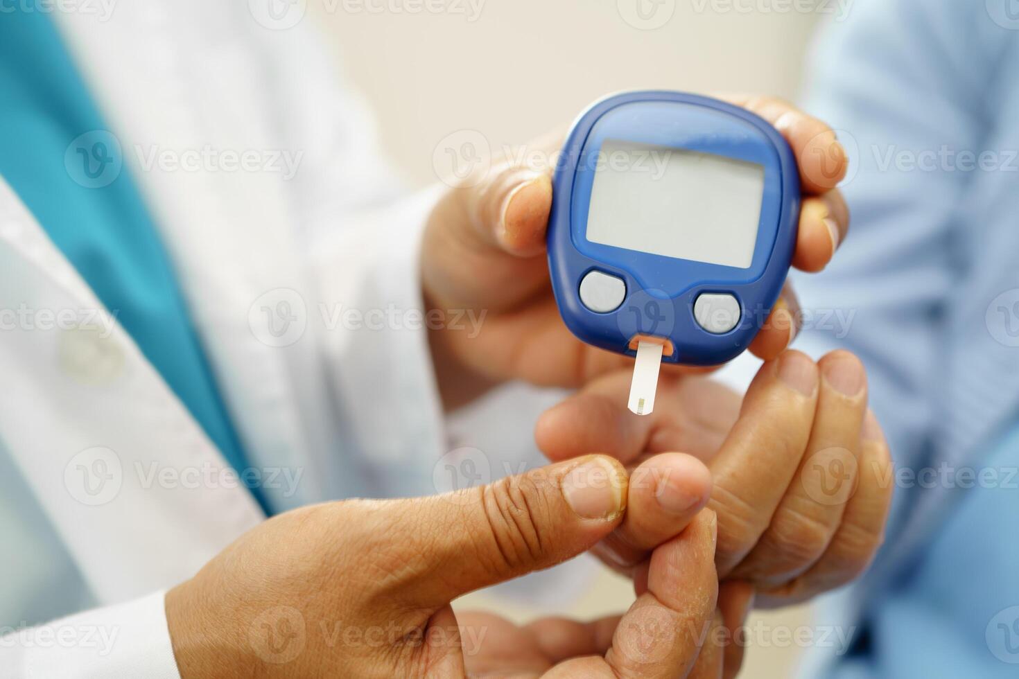 Asian doctor using digital glucoeter for check sample blood sugar level to photo