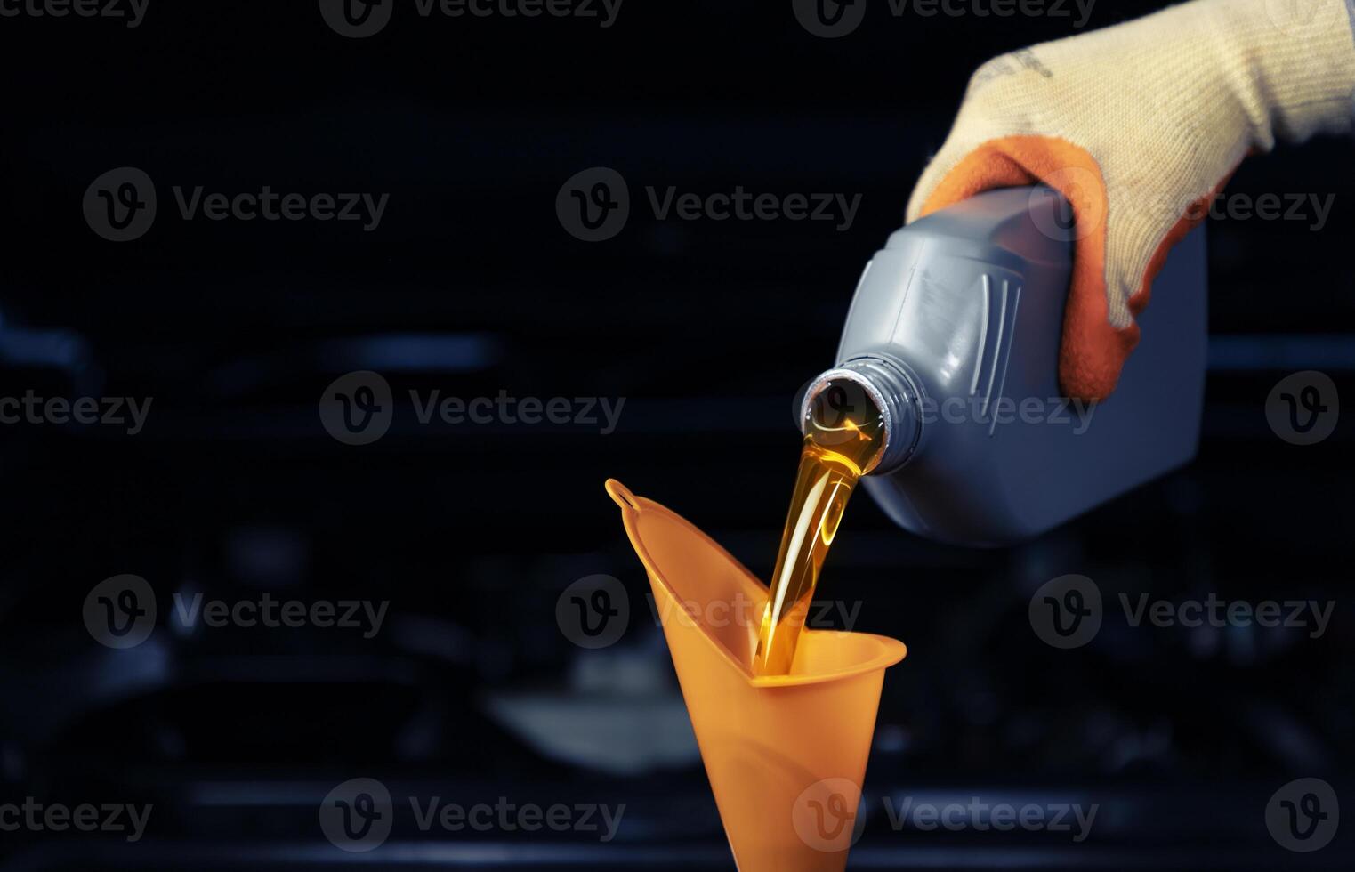 Car mechanic, oil change or fuel from a bottle of engine lubricant, service industry, automobile and engine repair technology.. . photo