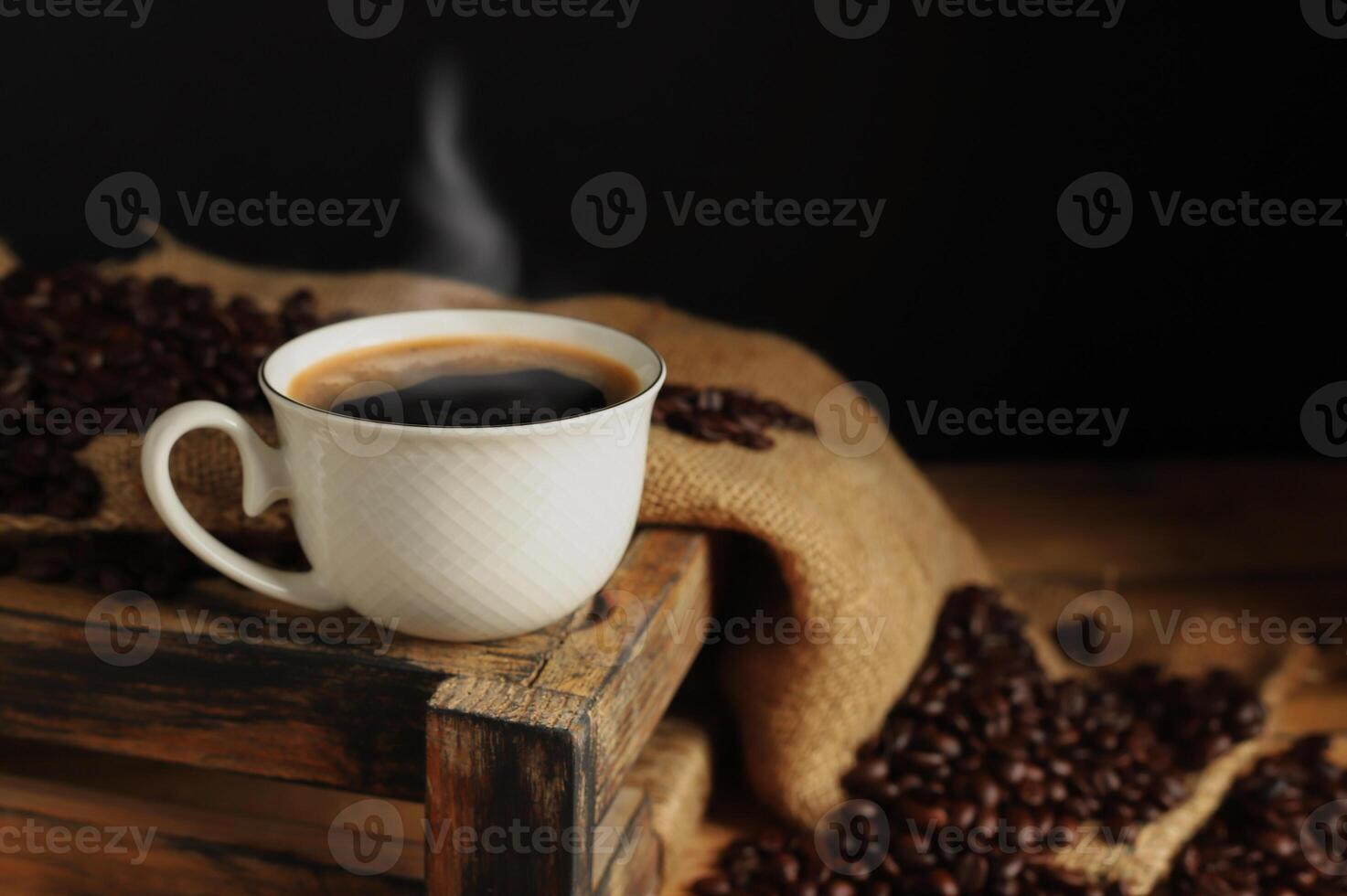 Coffee cups with roasted coffee beans arranged on a table with a black and dark background.. photo