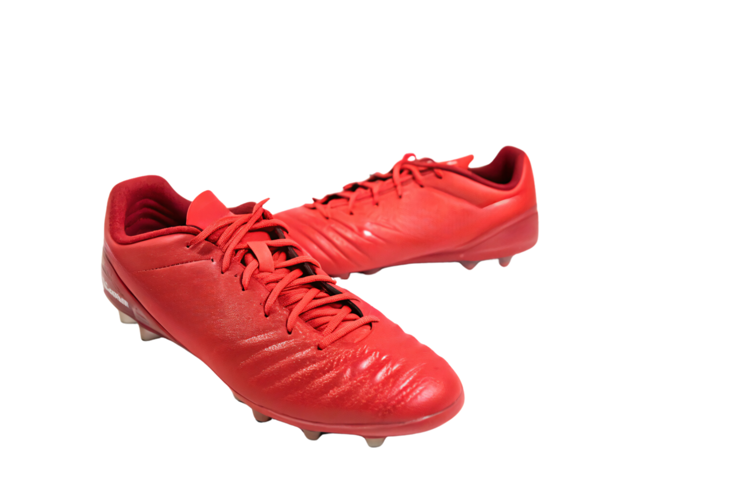 Minimalist red soccer cleats featuring smooth contours and lightweight material, ensuring speed and agility for players seeking a bold and striking sportswear option png