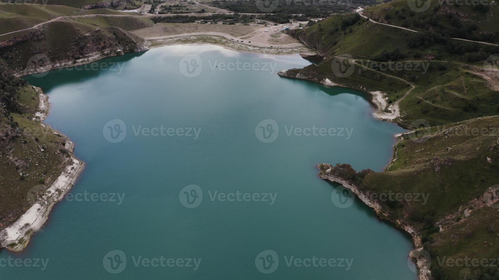 A lake nestled in the mountains from above. photo