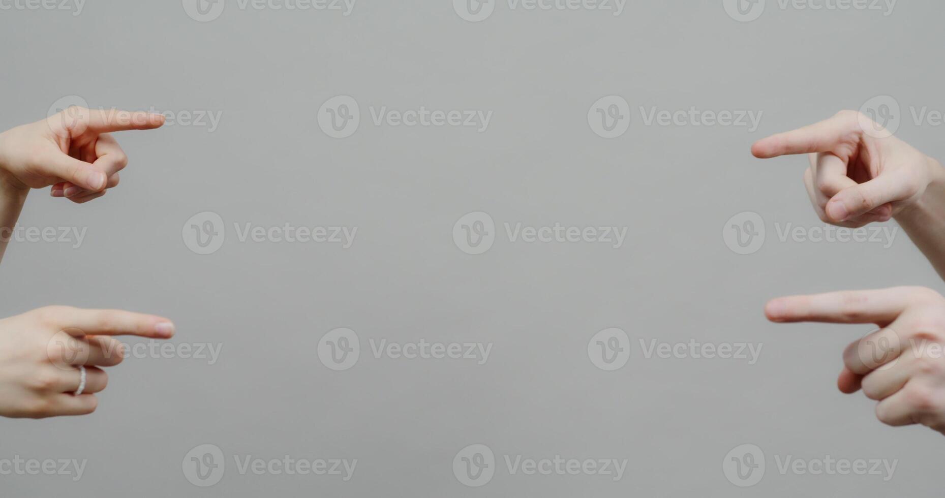 Four hands pointing at each other on a gray background photo