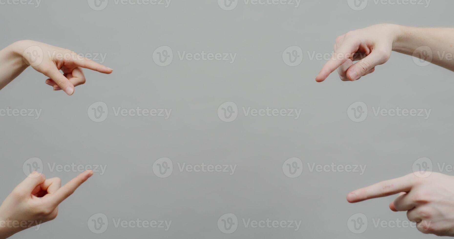 Four people pointing at the middle with their hands photo