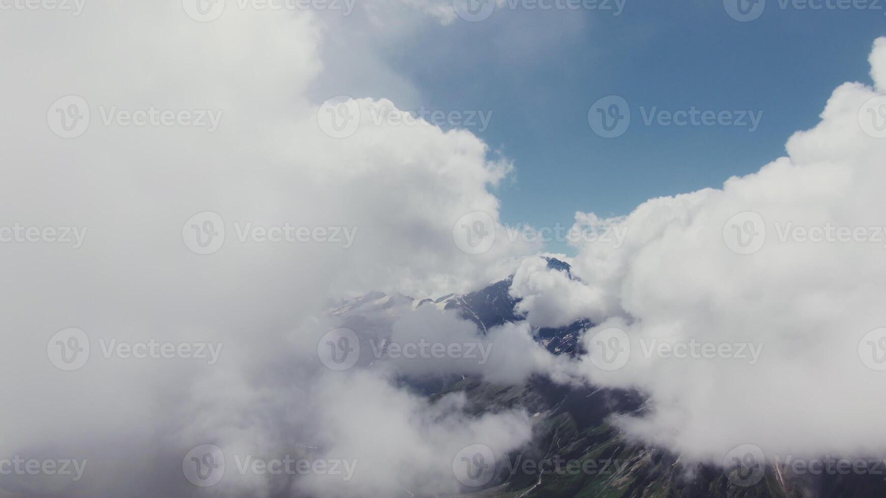 A panoramic view of a valley surrounded by mountains and clouds photo
