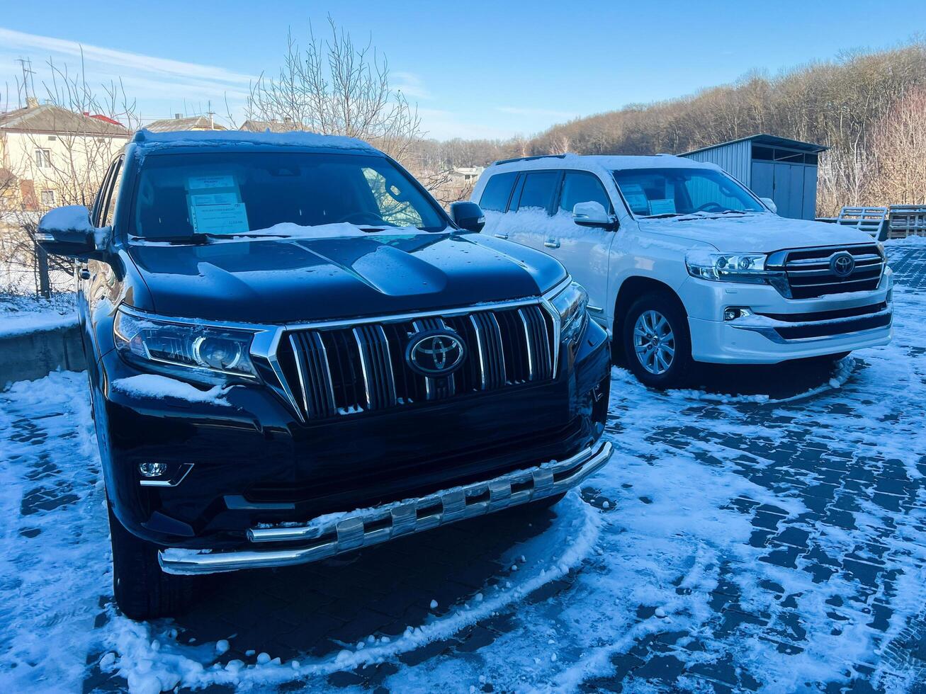 Kyiv, Ukraine - March 04, 2025- Black and white Toyota Land Cruiser SUVs parked outdoors on a snowy winter day photo