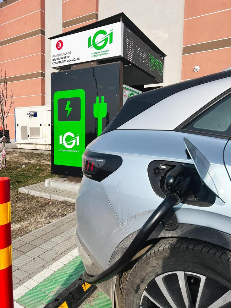 Lviv, Ukraine - February 12, 2025- Electric Volkswagen ID.4 car charging at a modern charging station in urban environment photo