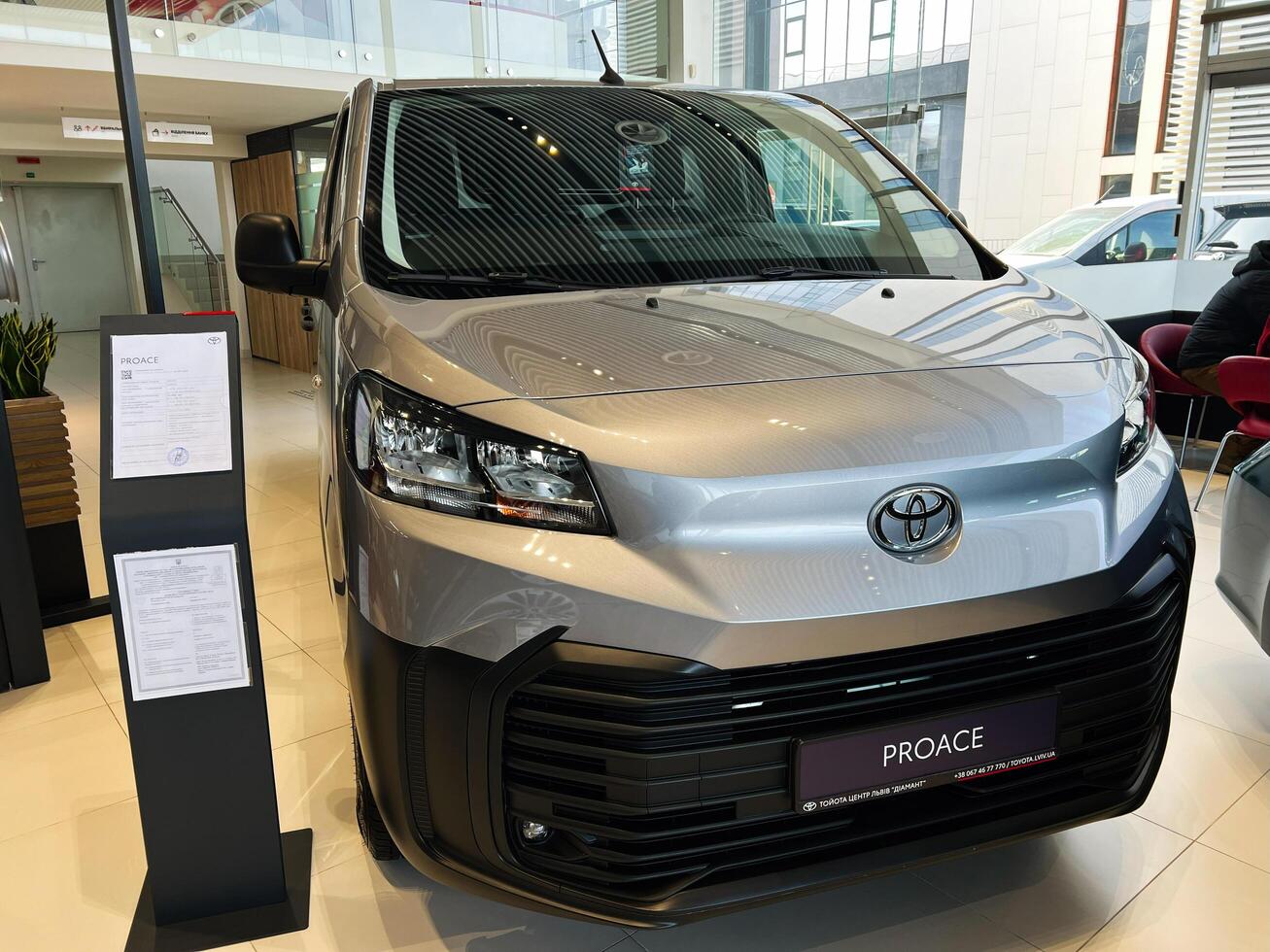 Lviv, Ukraine - February 12, 2025- Silver Toyota Proace displayed in a modern vehicle showroom with informative placard photo
