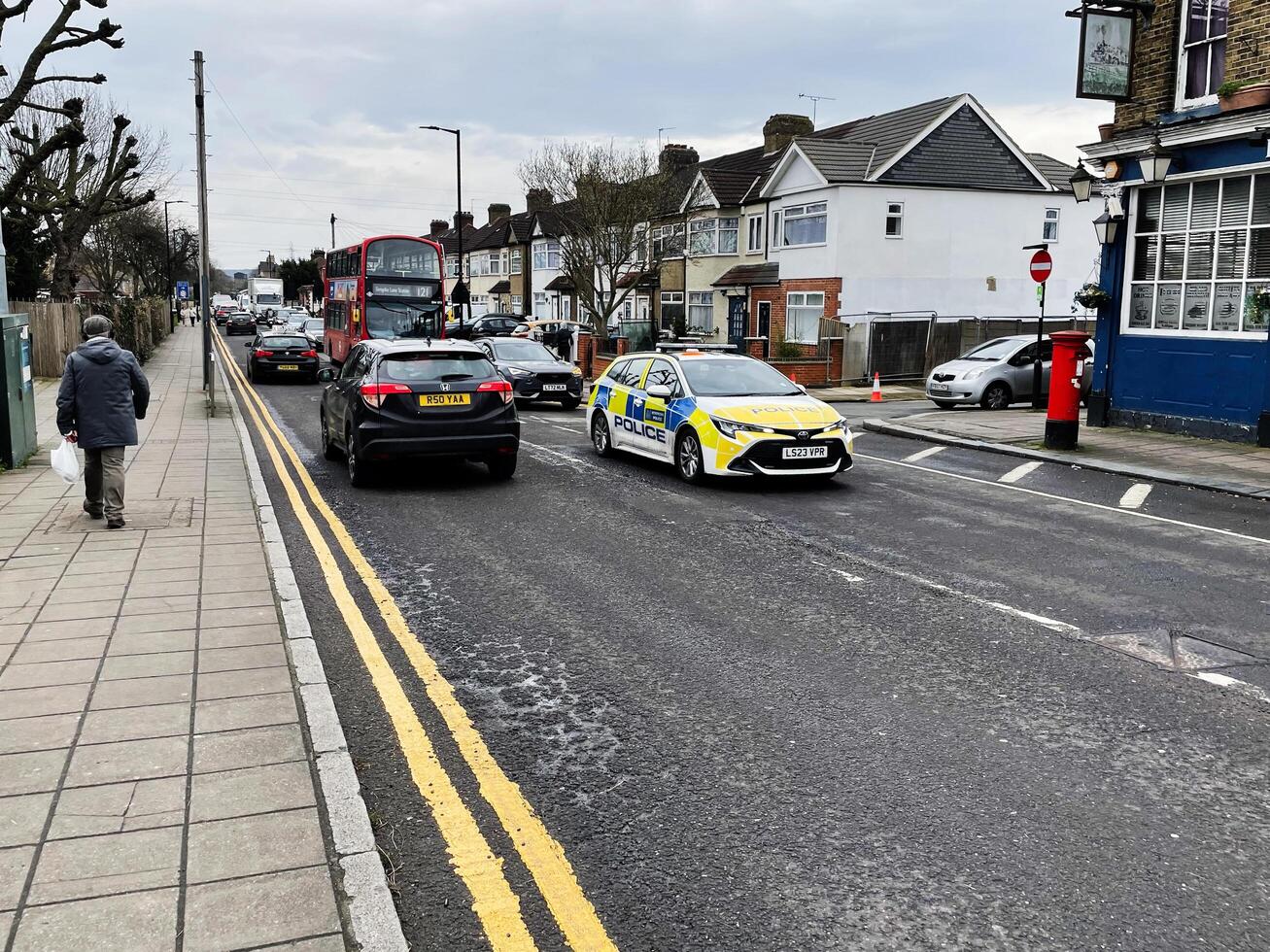 London, UK - March 02, 2025- Police car and bus on a busy street in Enfield, London, UK photo