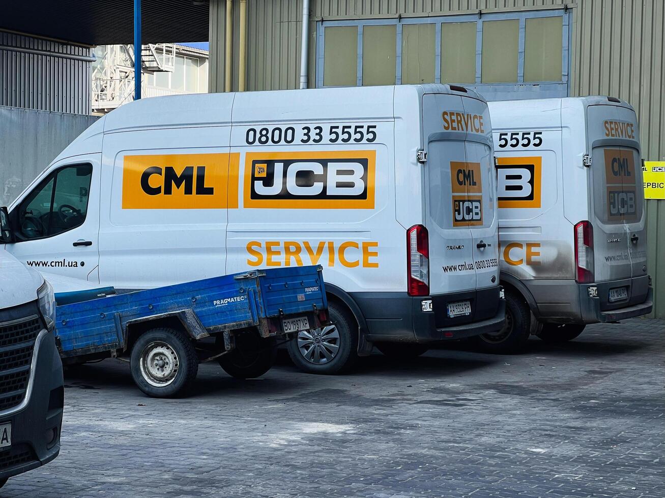 Commercial service JCB vans parked outside an industrial building in urban background photo