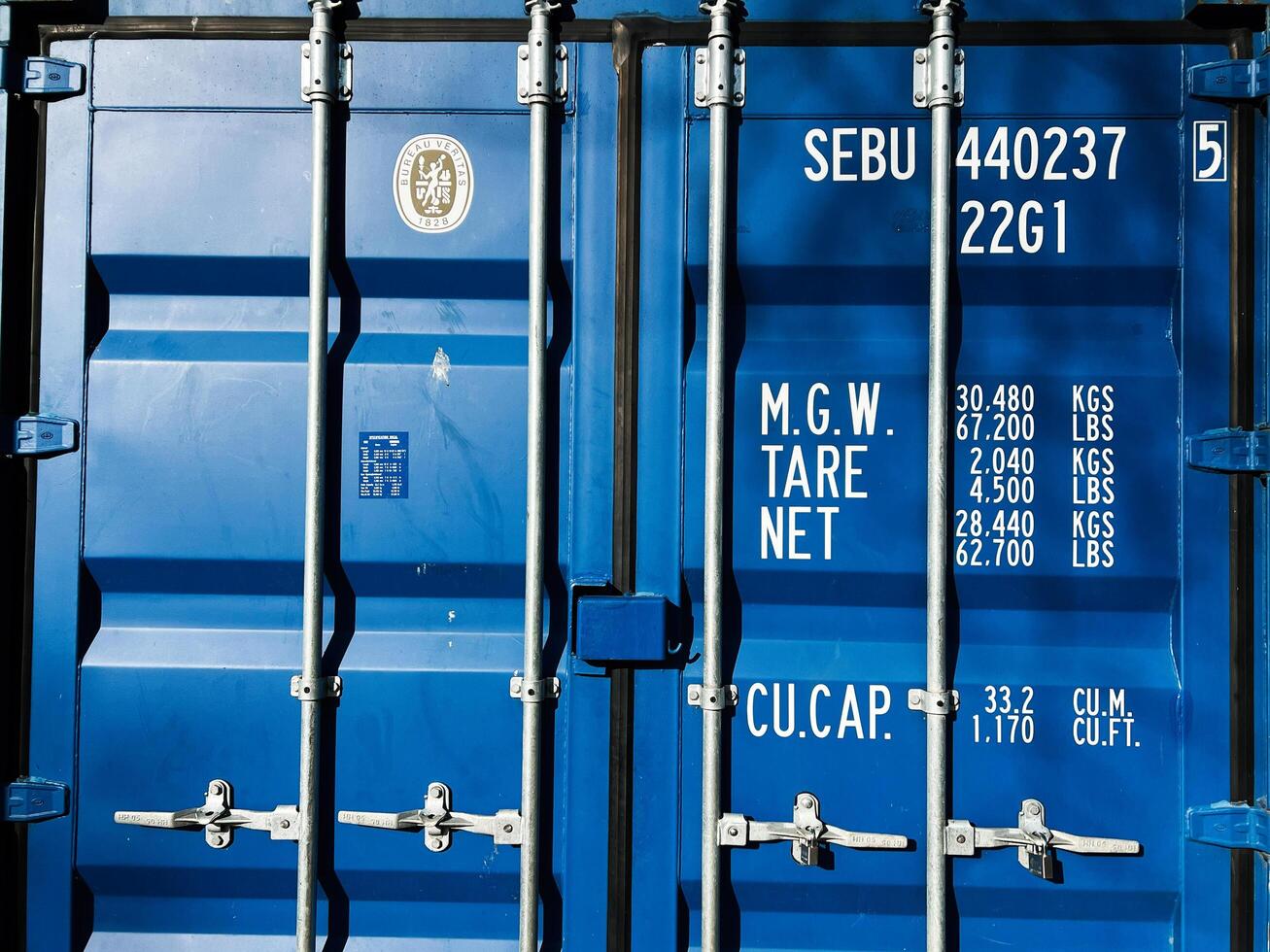 Blue shipping container door with weight details and secured locking mechanism photo