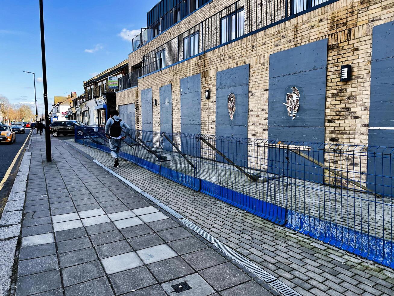 London, UK - March 02, 2025- Urban street view with pedestrian and modern brick building in the background photo