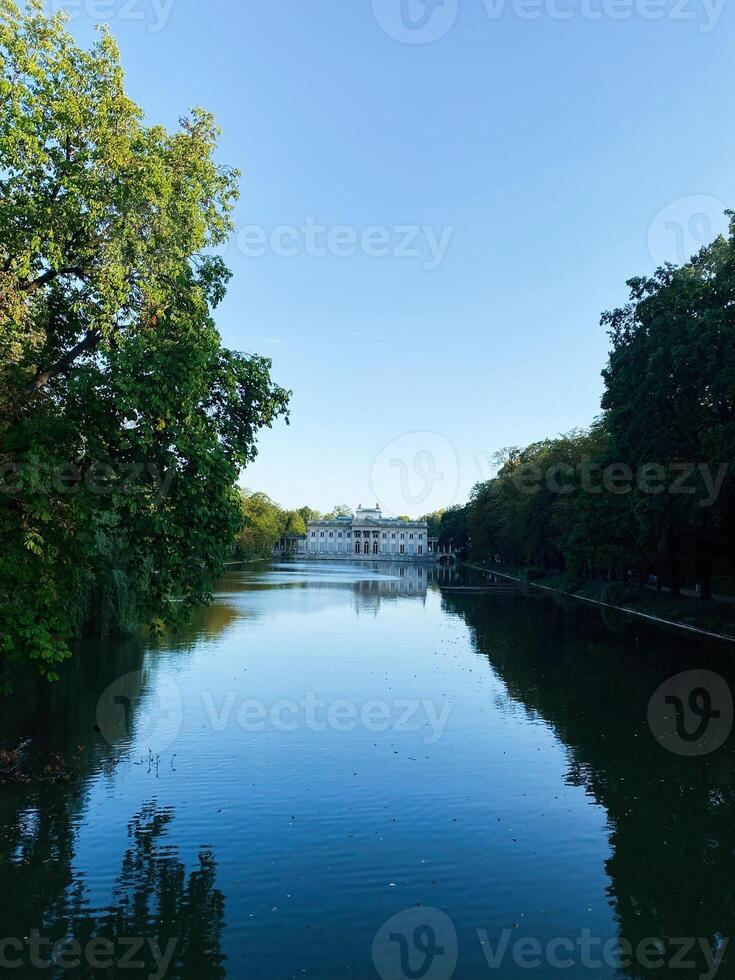 Historic Palace on the Isle surrounded by serene water and greenery under a clear sky photo