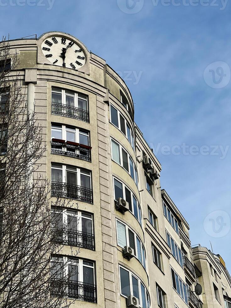 Building with a rooftop clock and large windows under clear blue sky photo