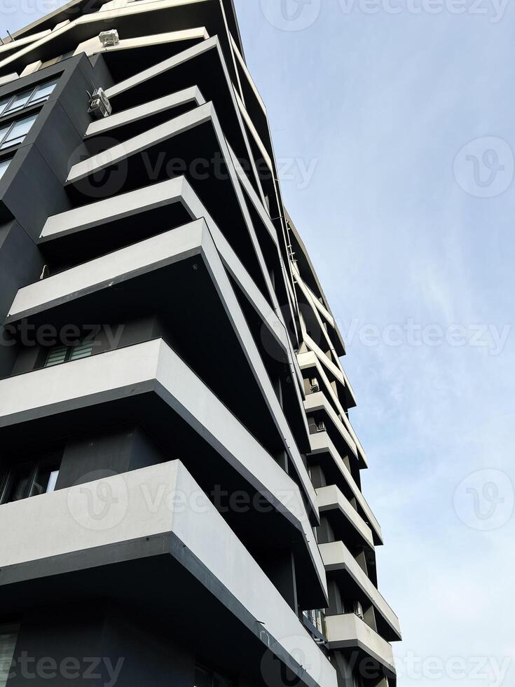 Modern apartment building with geometric balconies against a clear sky view photo