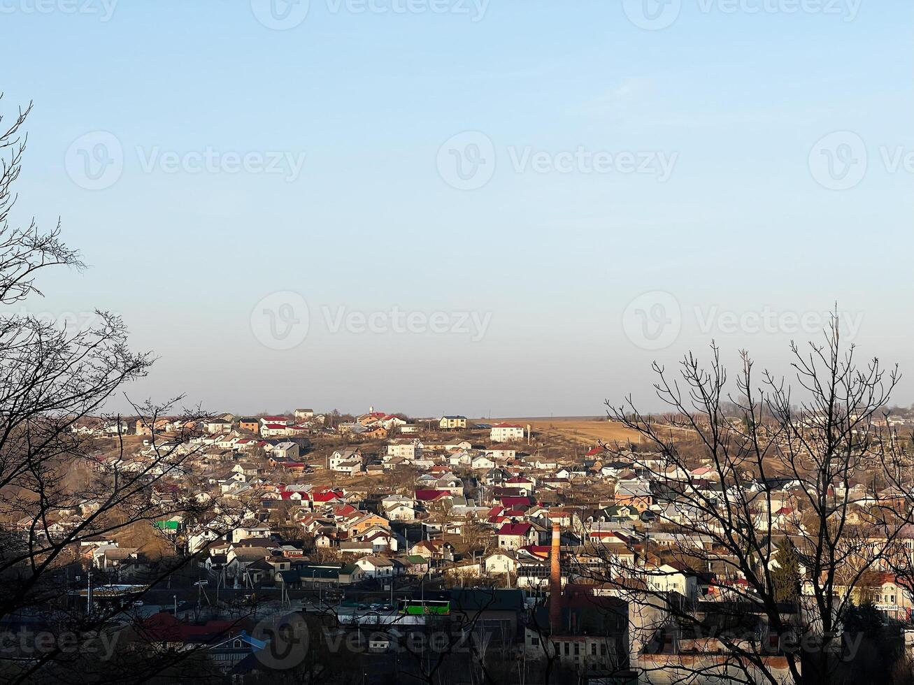Scenic view of a picturesque small town among fields and trees under blue skies photo