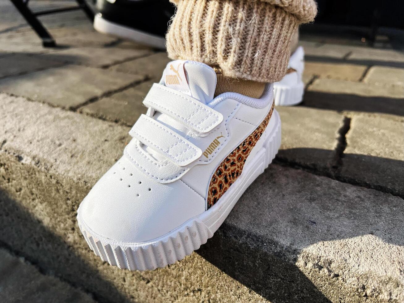Kyiv, Ukraine - March 10, 2025- Close-up of stylish Puma toddler shoe with leopard print pattern outdoors photo