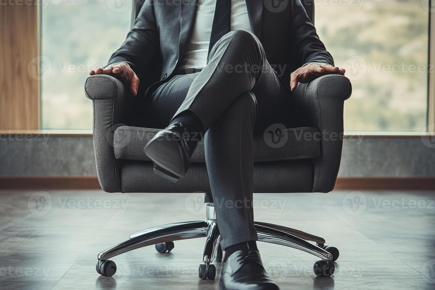 A man in a suit and tie sits in a chair photo