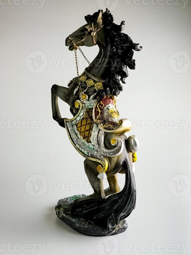 Statuette of a horse in multi-colored harness. The horse is rearing. photo