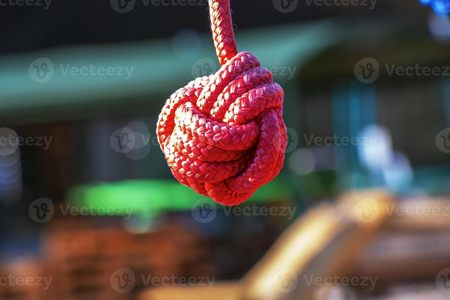 Close up of rope knot on children's playground in public park. Red photo
