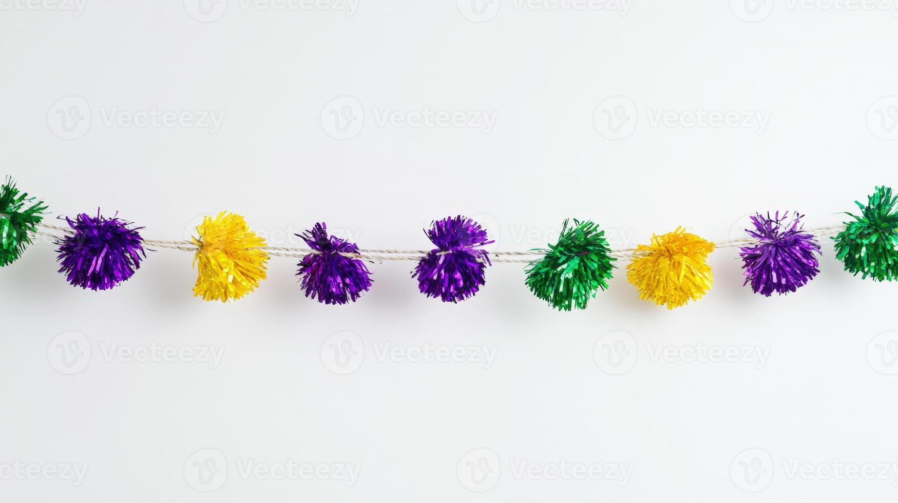 A garland of pom poms hanging on a white wall photo