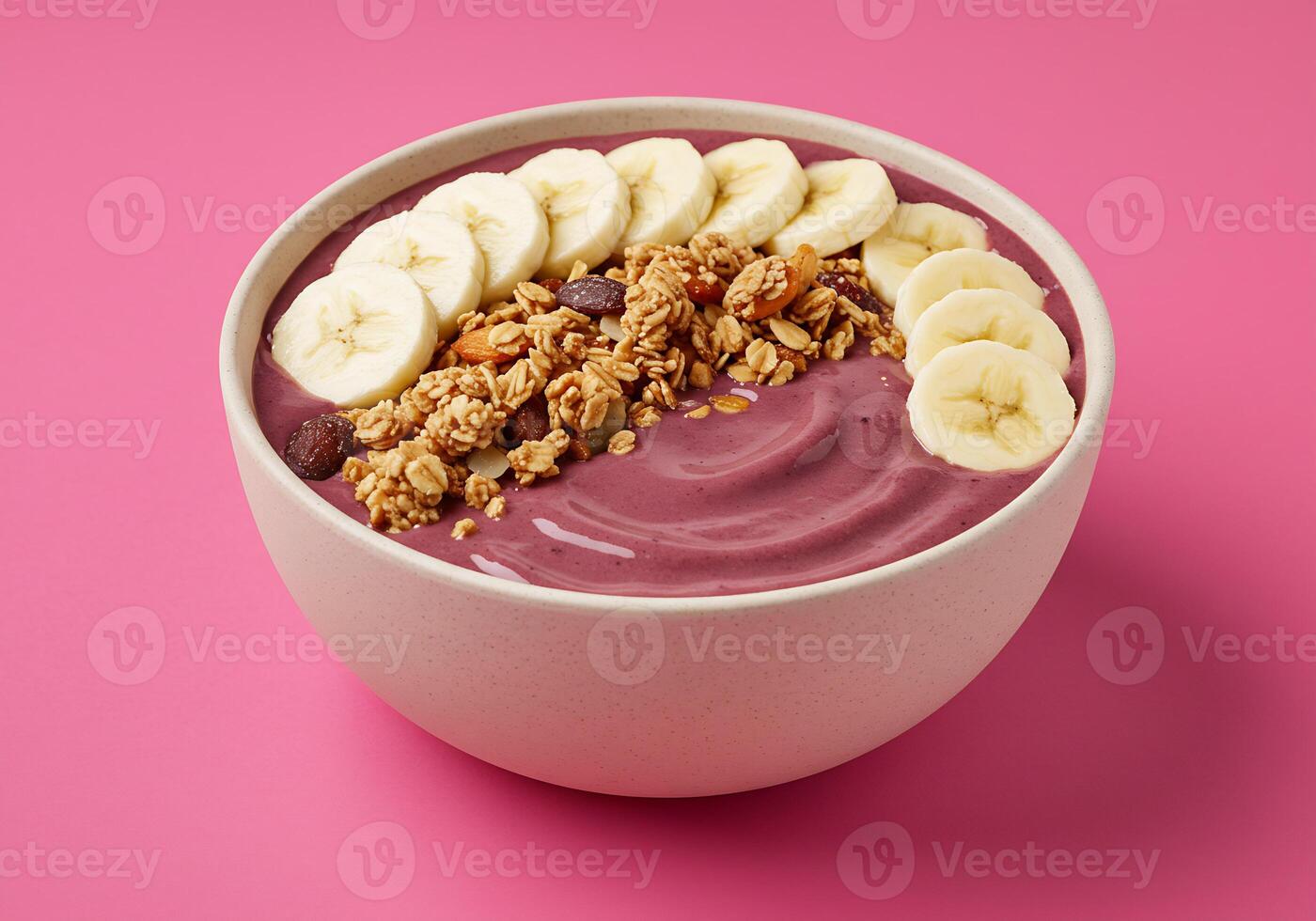 Acai Bowl with Granola and Banana Slices on Pink Background photo