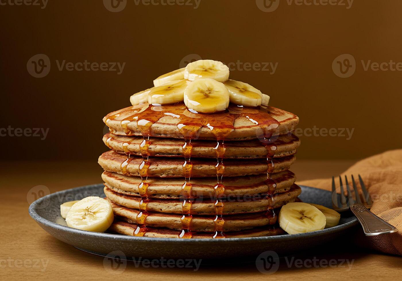 A Stack of Buttery Pancakes Topped with Banana Slices and Syrup photo