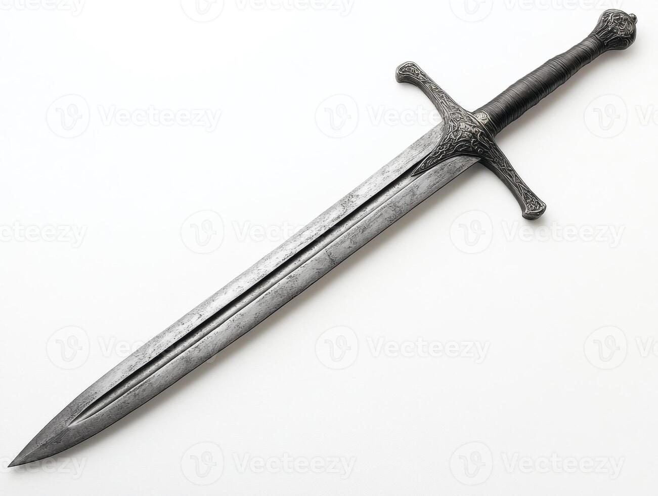 Detailed medieval sword resting on a surface with intricate design photo
