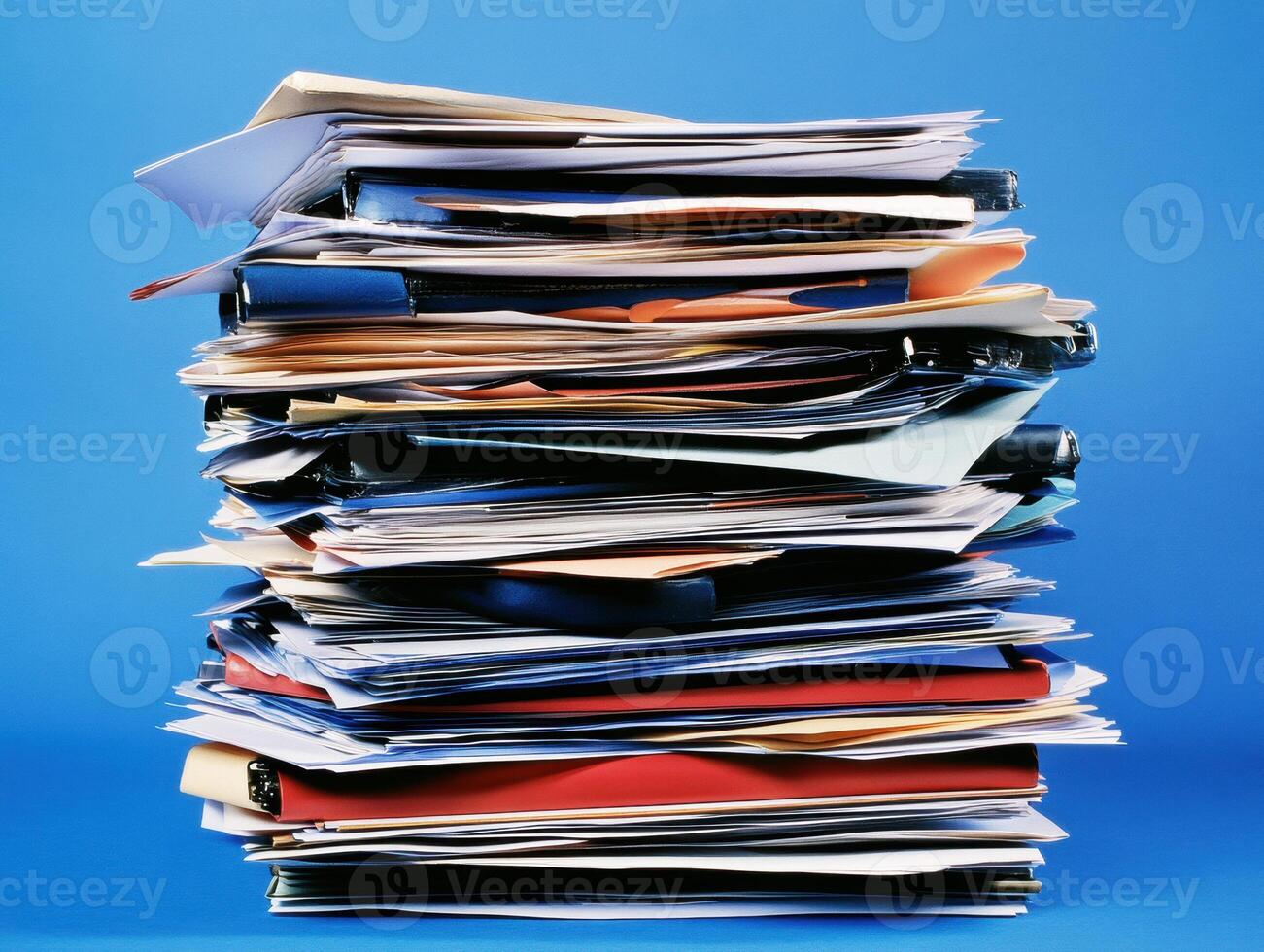 Piled documents and papers on a blue background in an office space photo