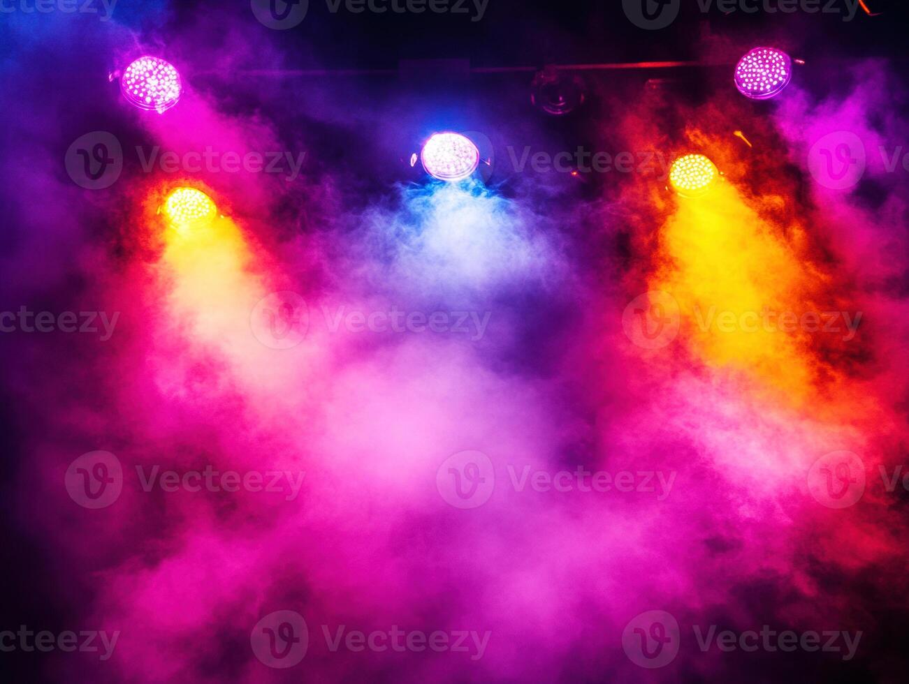 Colorful lights shine in a smoky atmosphere during a show photo