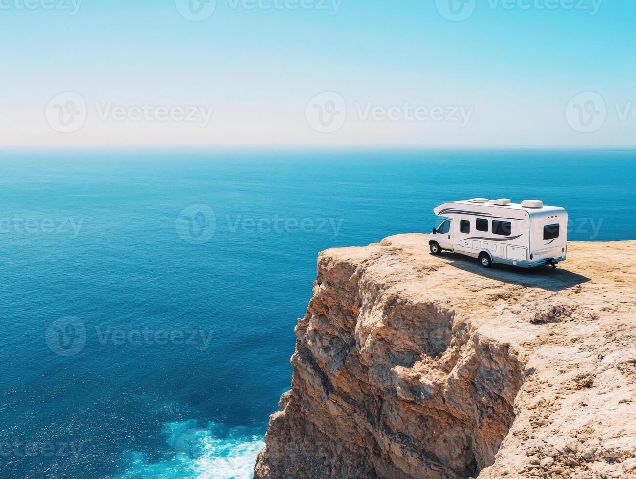 RV parked on cliff overlooking clear blue ocean during day photo