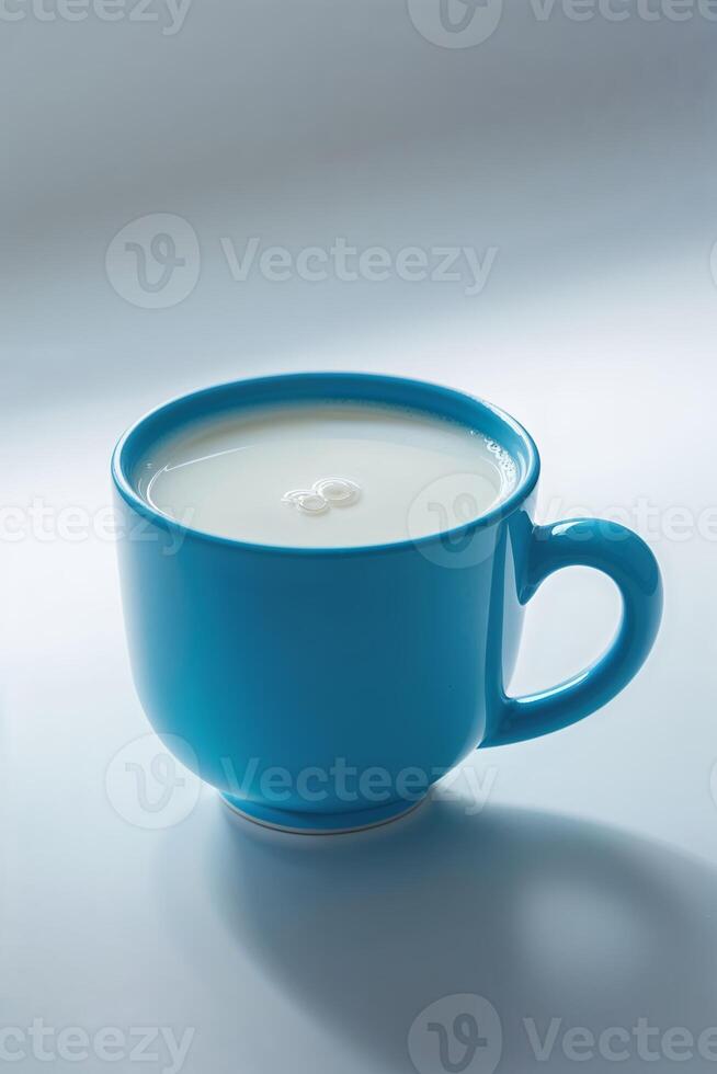 Cup filled with fresh milk on a light surface during daytime photo