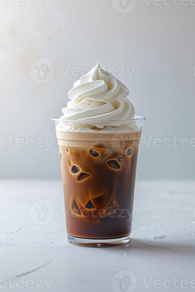 Refreshing iced coffee topped with whipped cream served in a clear cup on a light background photo